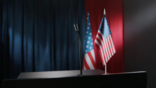 Empty press conference podium with microphone and American flags ready for political speech. Video serves as background for news broadcasts, election campaigns, or political reports close up shot