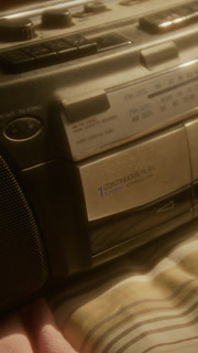 Vertical shot of hand of unrecognizable person inserting cassette tape into vintage boombox and pressing play. Clip is perfect for retro-themed lifestyle campaigns