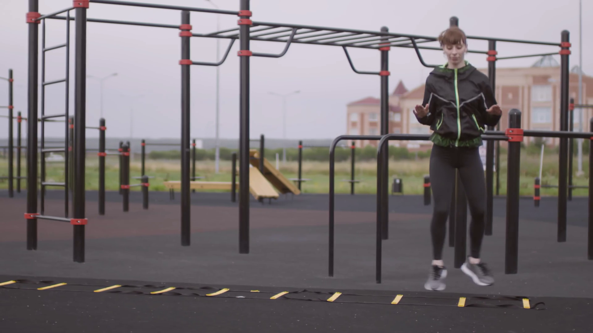 Female athlete in sportswear performing scissors and knee tuck jumps