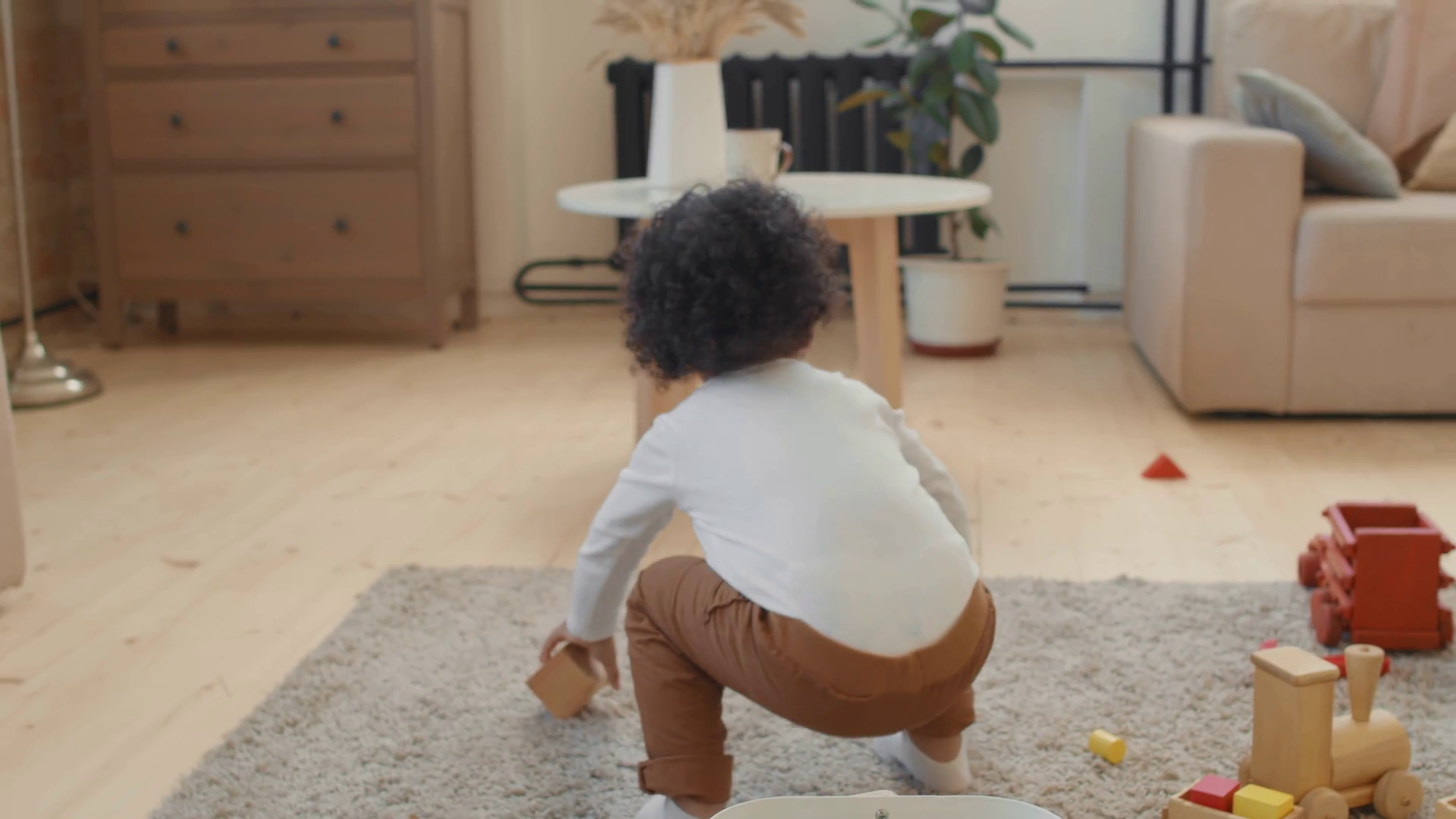 Handheld slowmo tracking of adorable black toddler boy throwing wooden