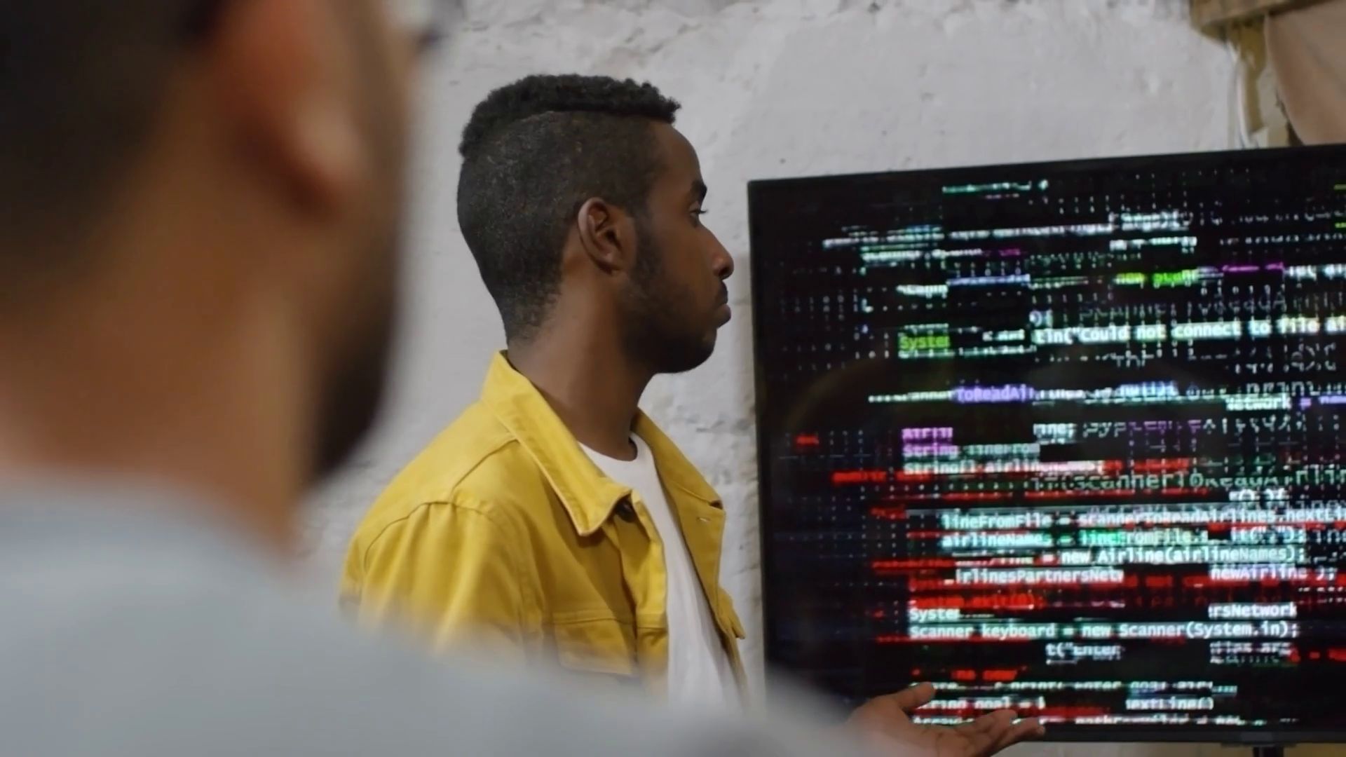Medium shot of two young men delivering presentation at programming