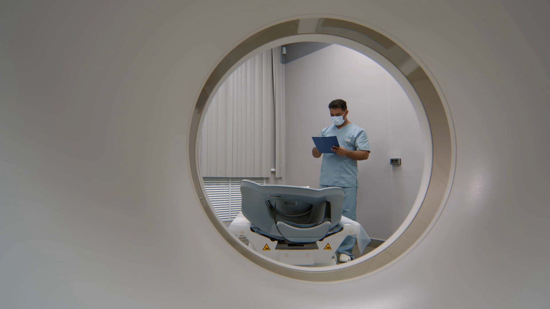 PAN shot through CT scanner of male doctor in face mask and scrubs