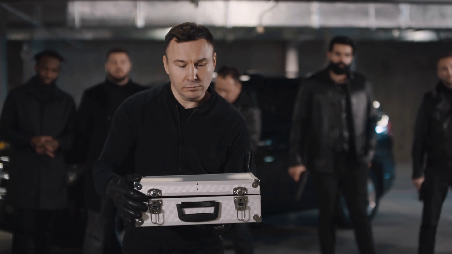 Slowmo of caucasian mafia member opening metal briefcase filled with