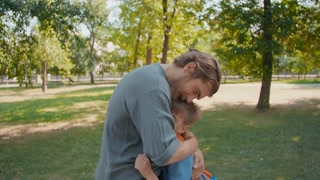 Slow motion shot of father embracing adorable schoolboy after dropping him off at school on a sunny morning