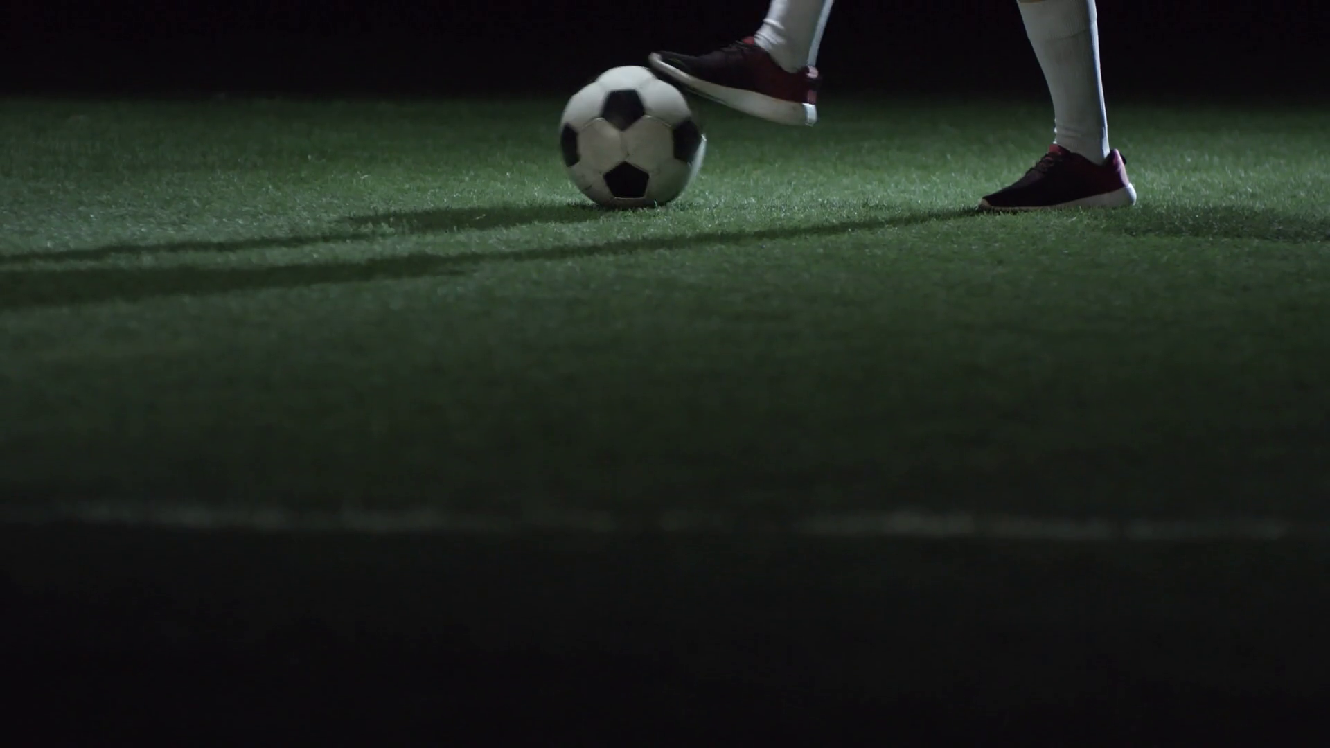 Tilt up of junior girl in professional uniform juggling soccer ball on