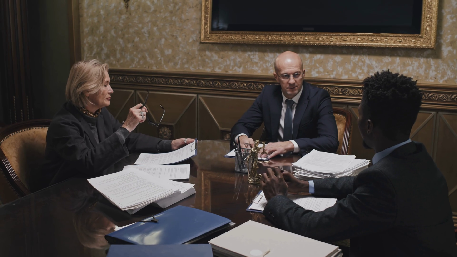Group of diverse lawyers sitting with documents at meeting table and