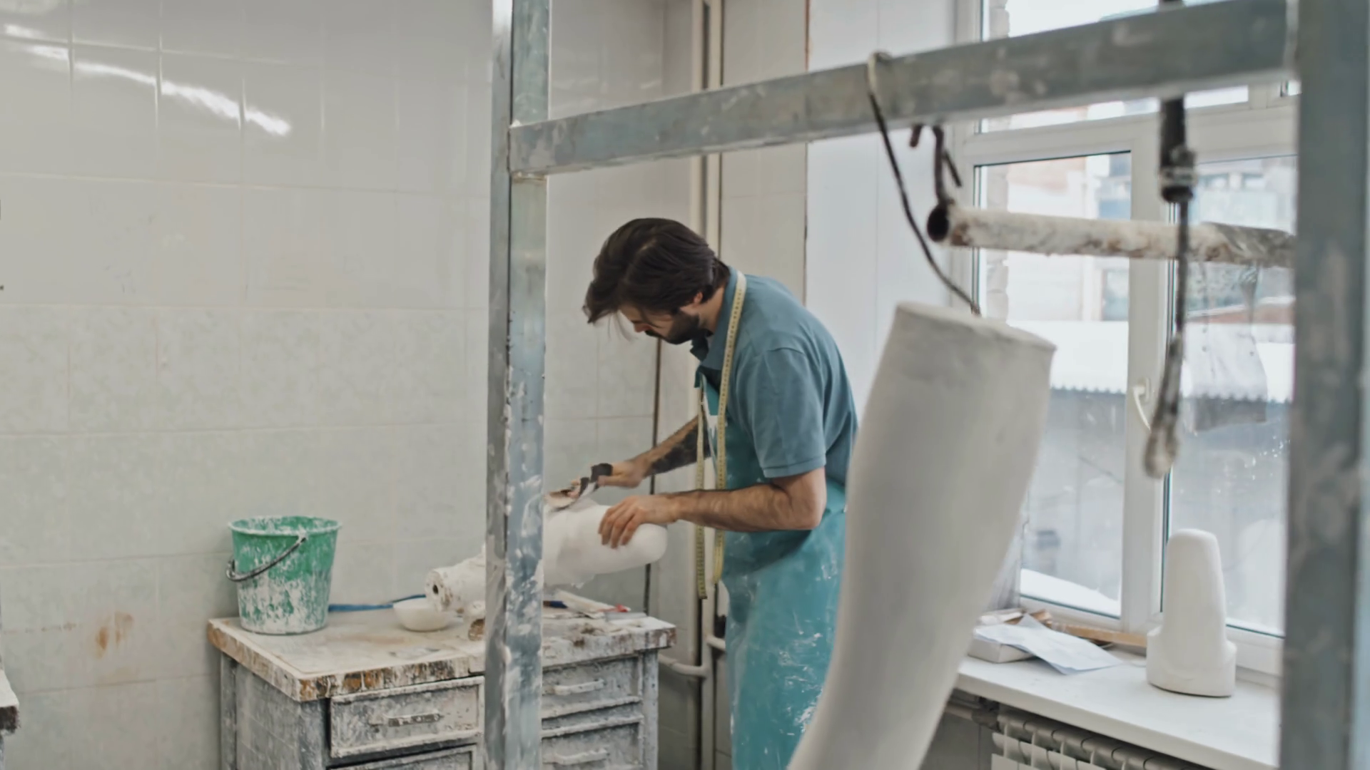 Handheld shot of young adult Caucasian man with beard on face polishing