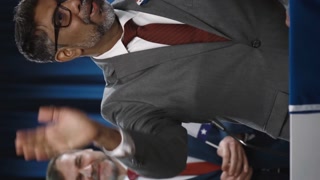Medium vertical footage of Indian or Asian American male presidential nominee or senator from Democratic party thanking public after speech, waving, leaving, with photo cameras flashing