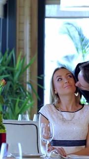 Romantic encounter: a man greets a woman with a kiss and a warm hug