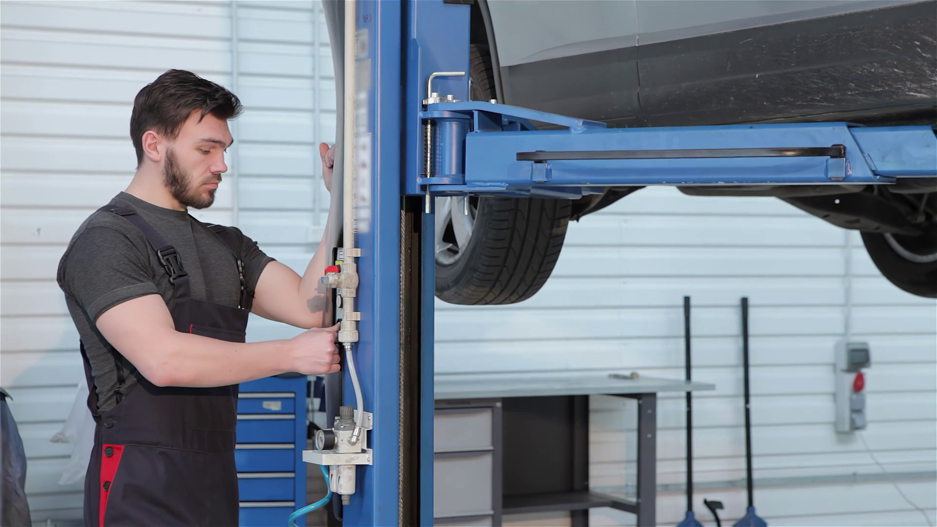 Skilled Mechanic Operates Hydraulic Lift To Stock Footage SBV-352085146 ...
