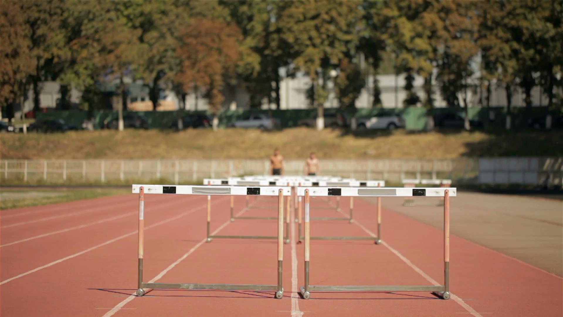 Two Sprinters Jumping Over Five Hurdles On Stock Footage SBV309848609