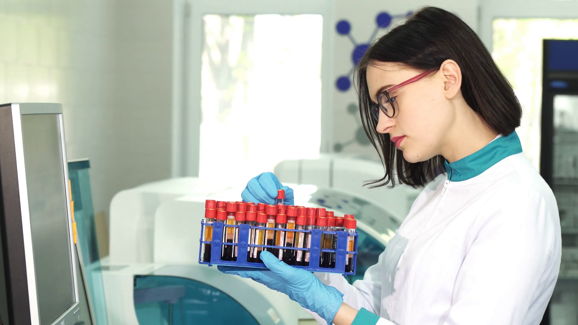 Attractive female young medical worker examining blood samples in test