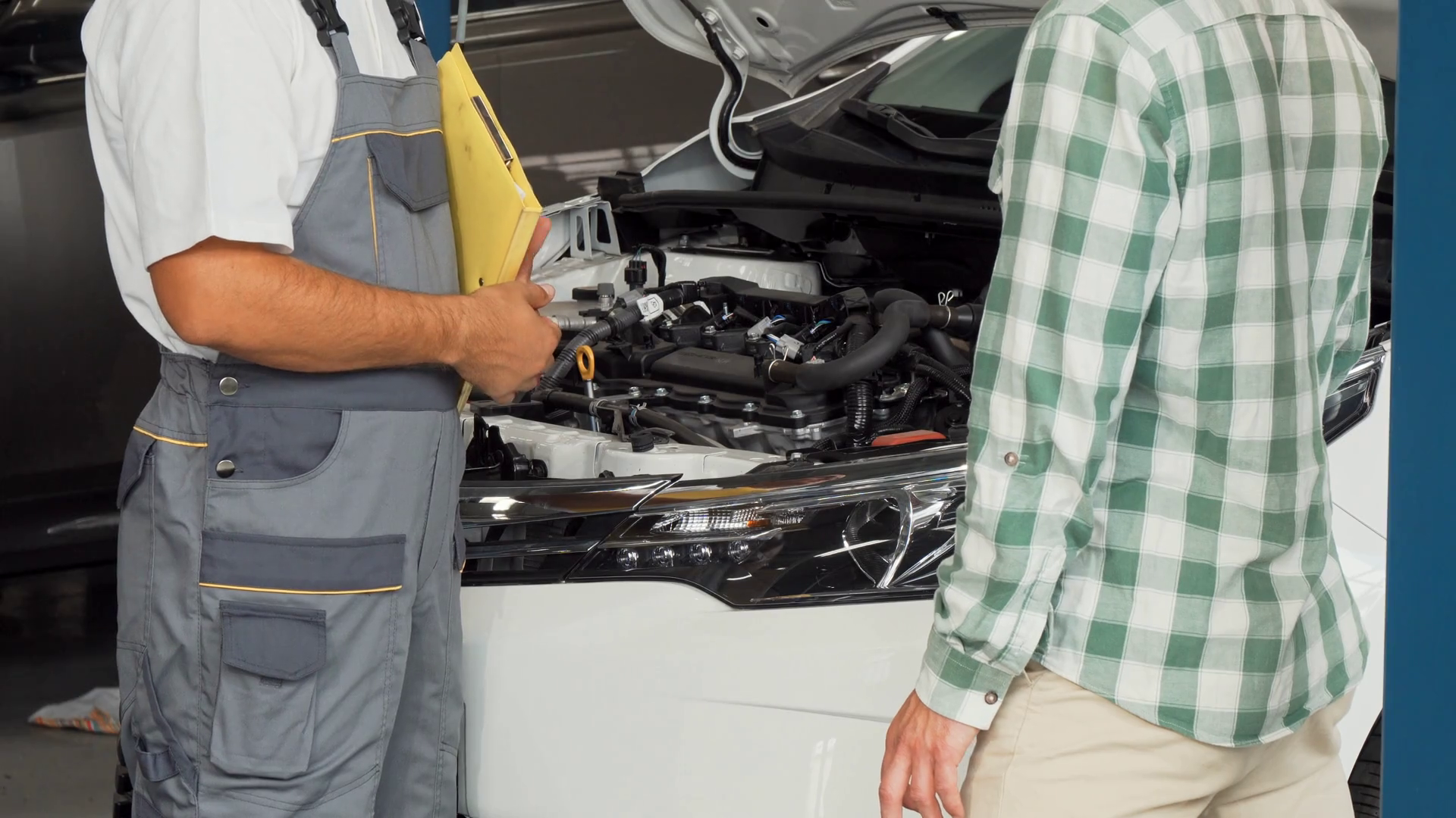 Car owner shaking hands with auto mechanic at the service station