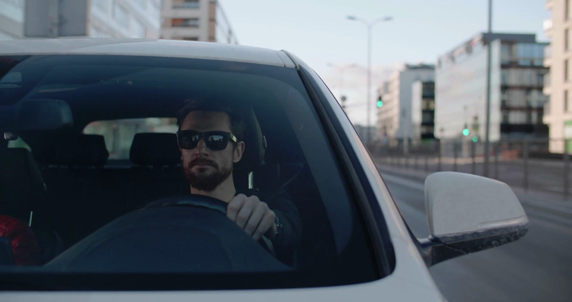 Man talking on the speakerphone while driving downtown Stock Video