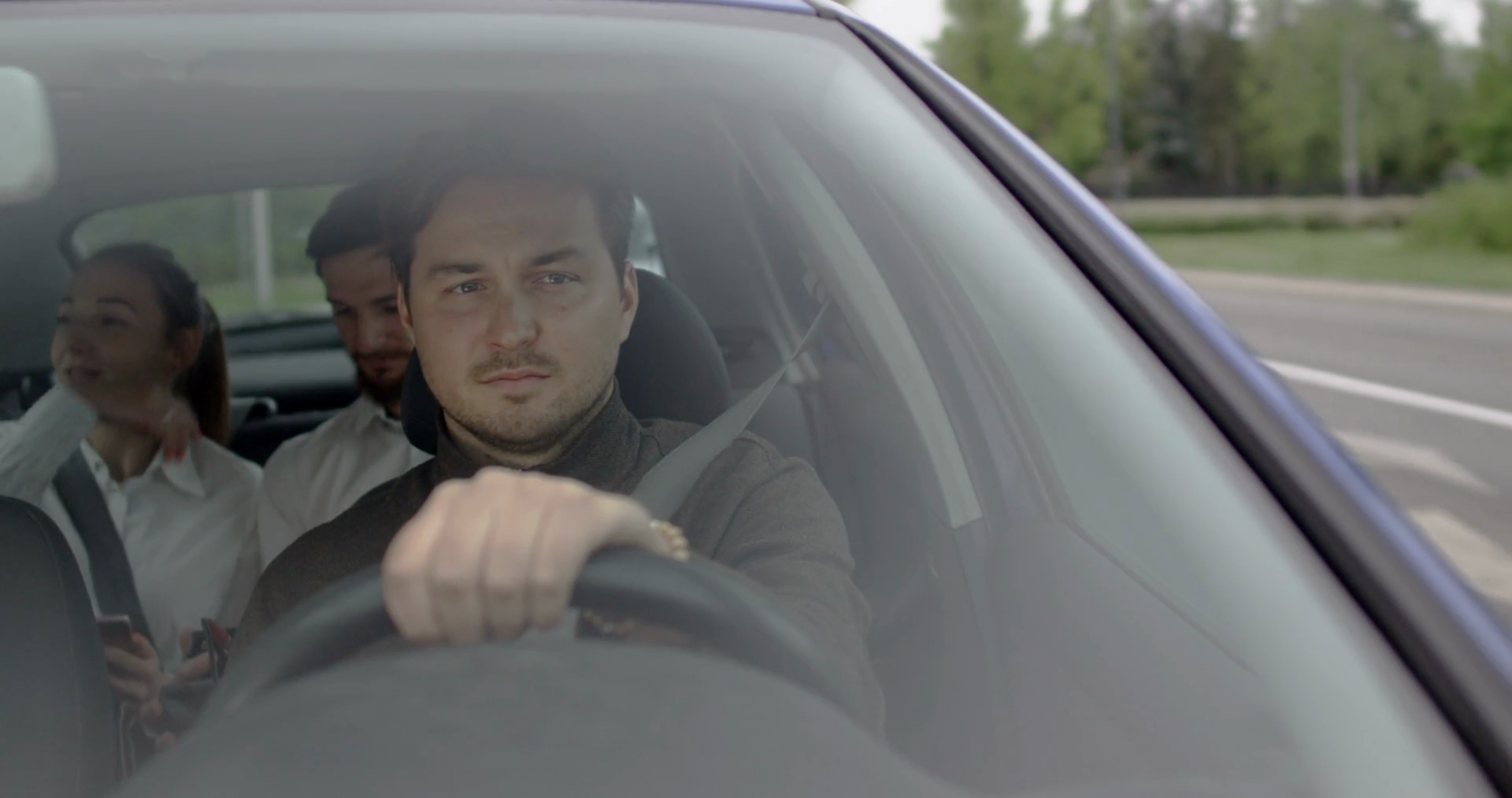 Concentrated driver on the city road with female and male client on