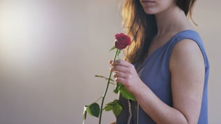 Woman Smelling a Red Rose and Throwing it Away
