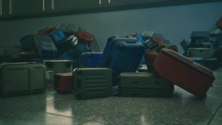 An abandoned airport terminal filled with neglected luggage piles in disarray