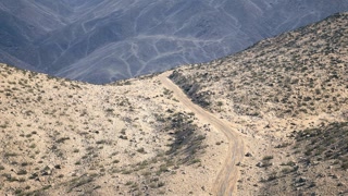Scenic view of a winding dirt road through rocky mountain landscape