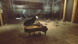 Solitary grand piano illuminated amidst nostalgic performance setting