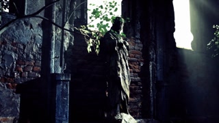 Mysterious statue stands in a dimly lit, overgrown urban ruin