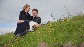 Romantic couple embracing on a hillside covered with flowers