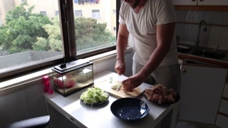 Man chopping onions on cutting board in kitchen