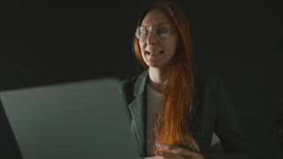 Businesswoman talking during a video conference call at night