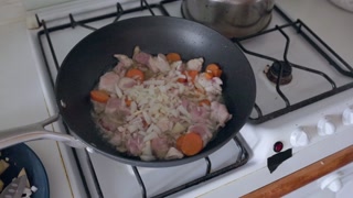 Chef adding diced onions to chicken stew