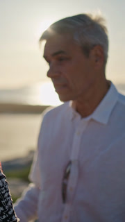 Senior couple talking on beach at sunset