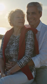 Senior couple embracing on beach at sunset, romantic moments