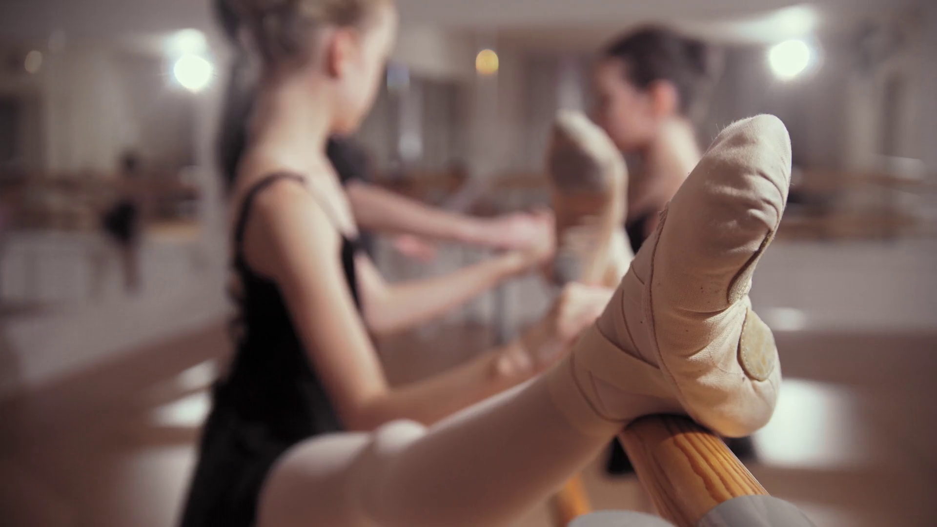 Ballet training ballerina girls in pointe shoes stretching by the
