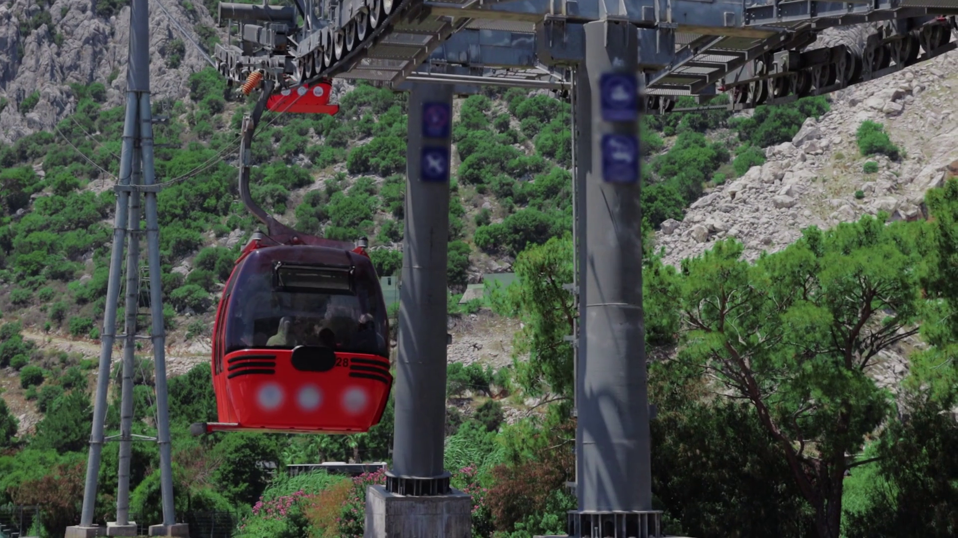 Red funiculars move along the cable car on the backdrop of mountains ...