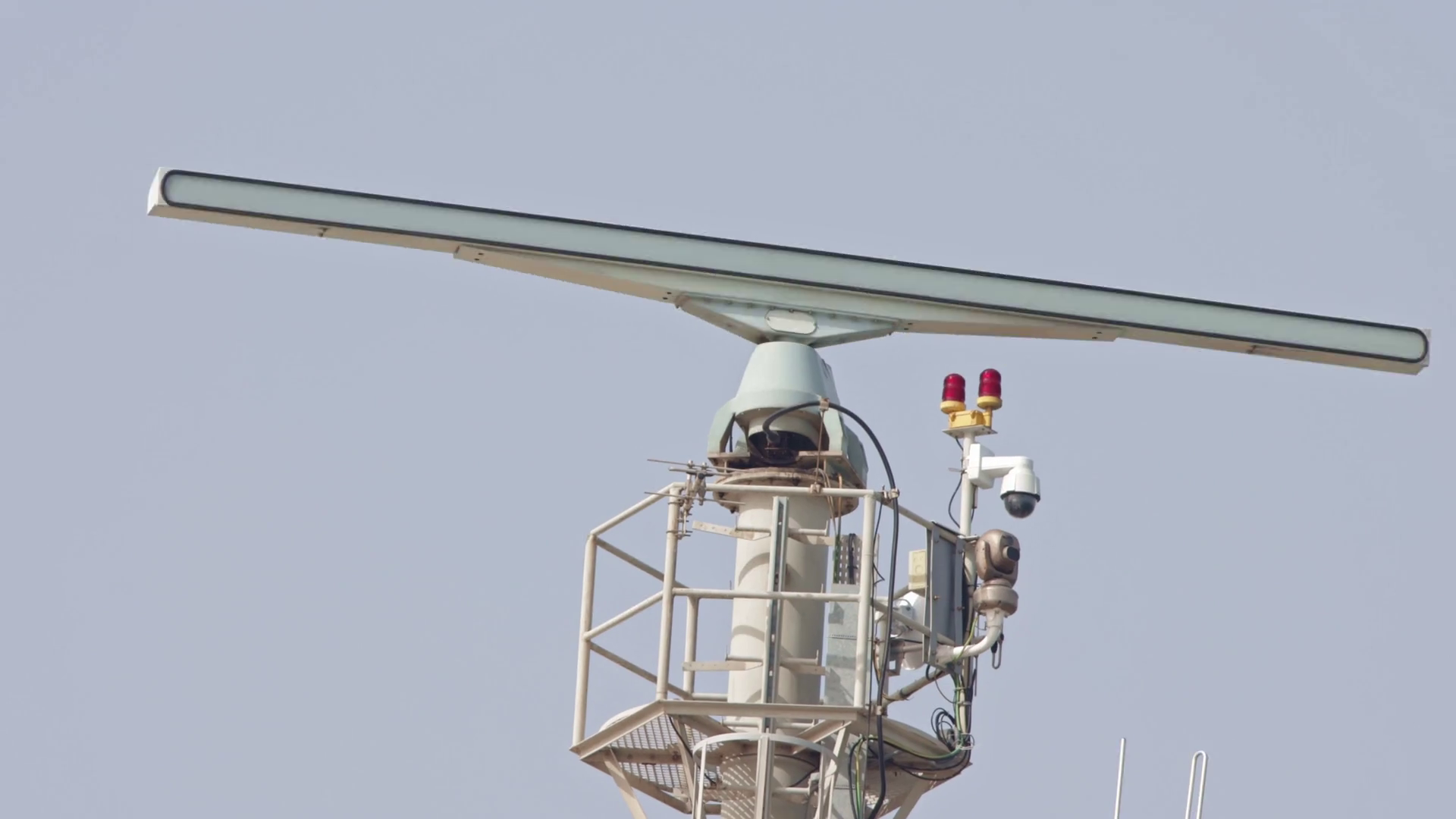 Spinning rotating radar equipment on top of a ship in front of the