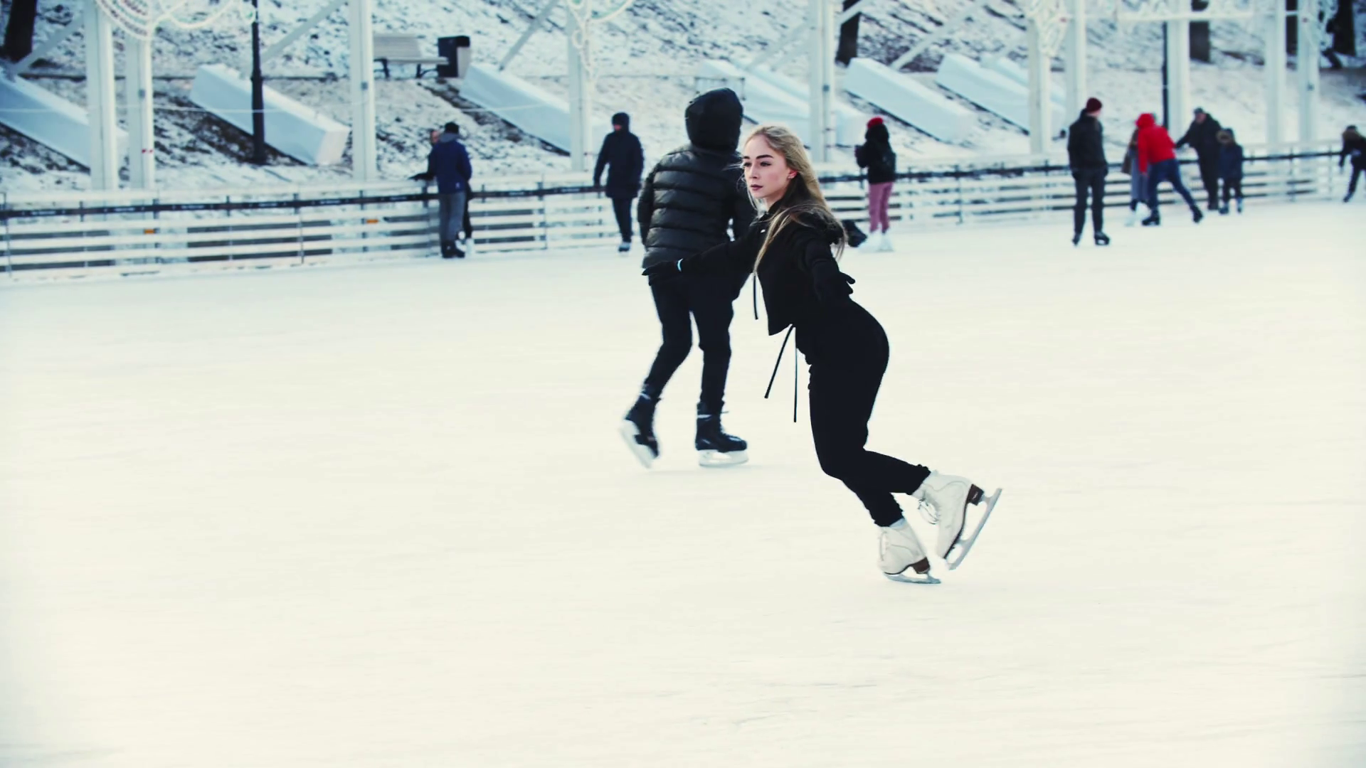 A young blonde woman professional figure skater skating on the outdoors