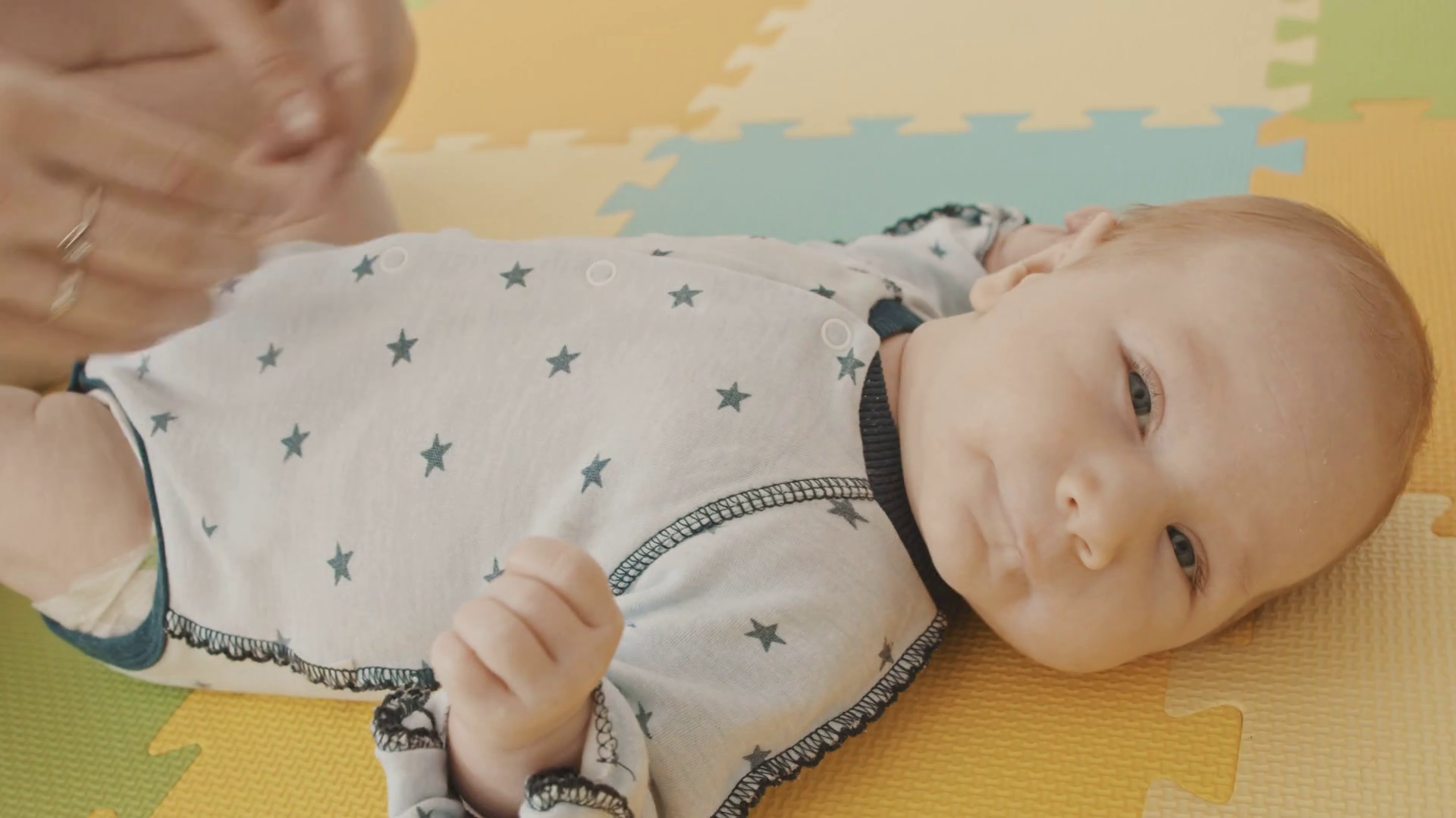 Baby lying on his back while his mother patting him Stock Video Footage