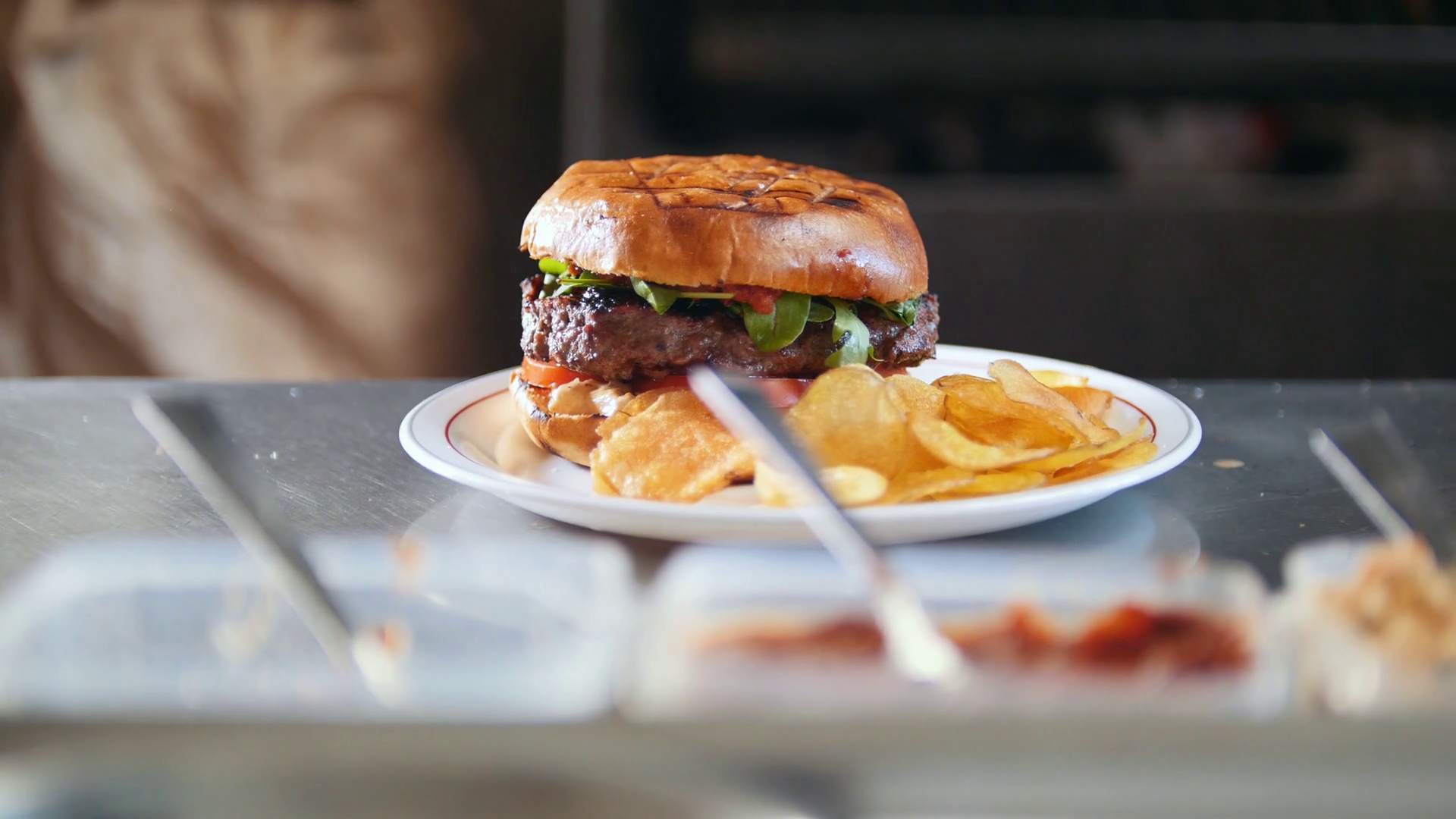 Burger with potato chips on a plate in restaurant kitchen Stock Video