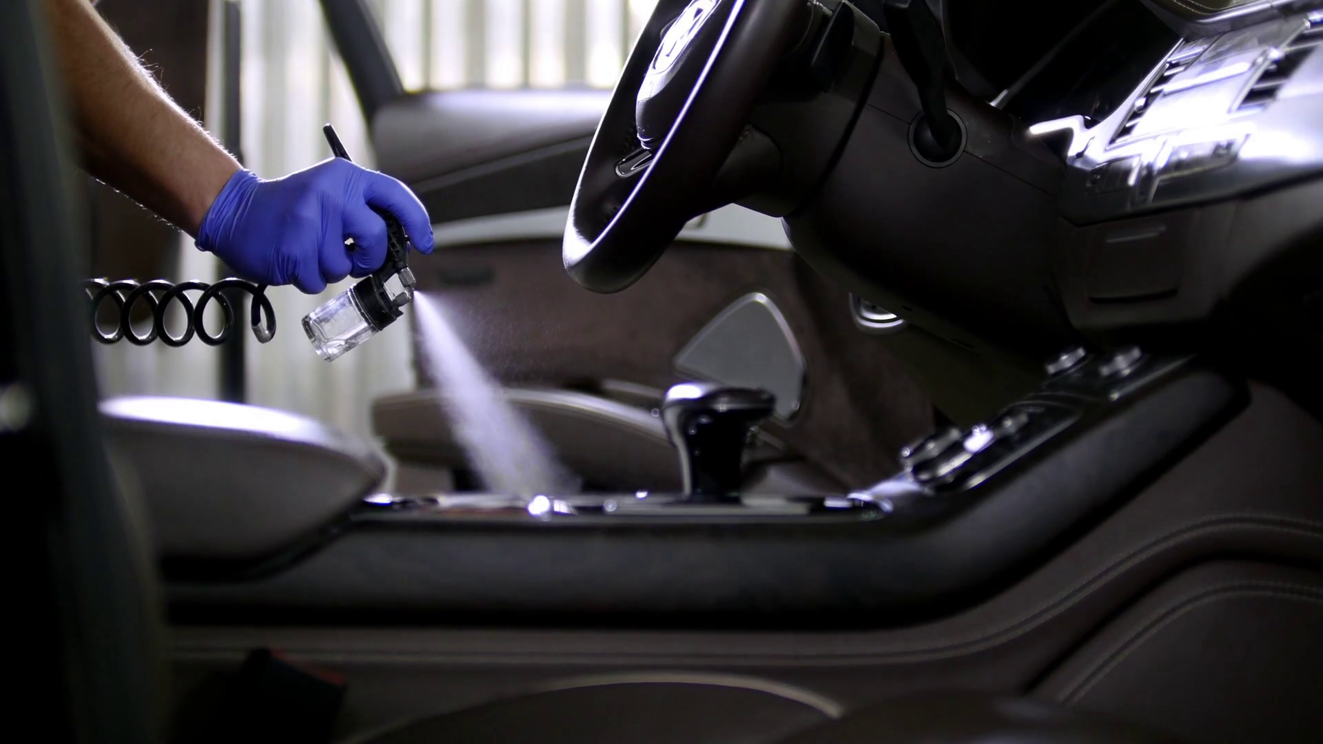 Car service. Spraying the cleaning agent in interior of the car Stock
