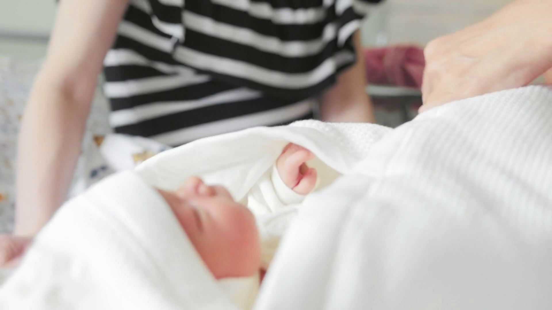 Maternity hospital employee of the hospital is swaddling a newborn