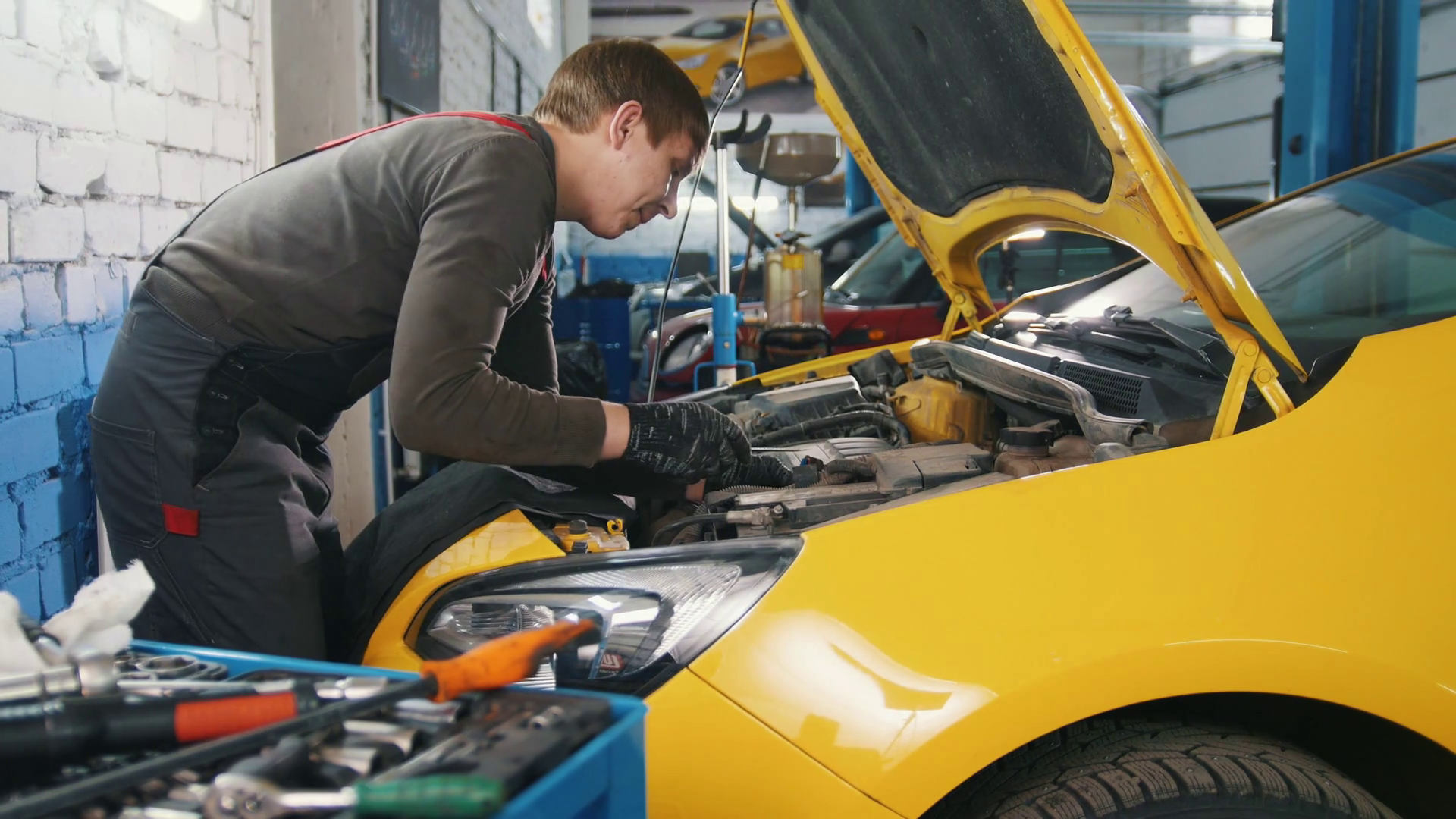 Mechanic in car service - repairing in engine compartment Stock Video ...