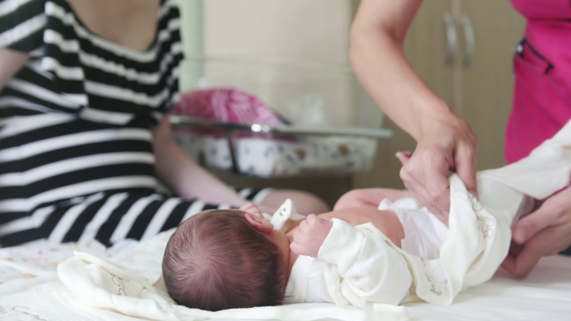 Newborn baby, mother and nurse swaddling the infant Stock Video Footage 0010 SBV316462758