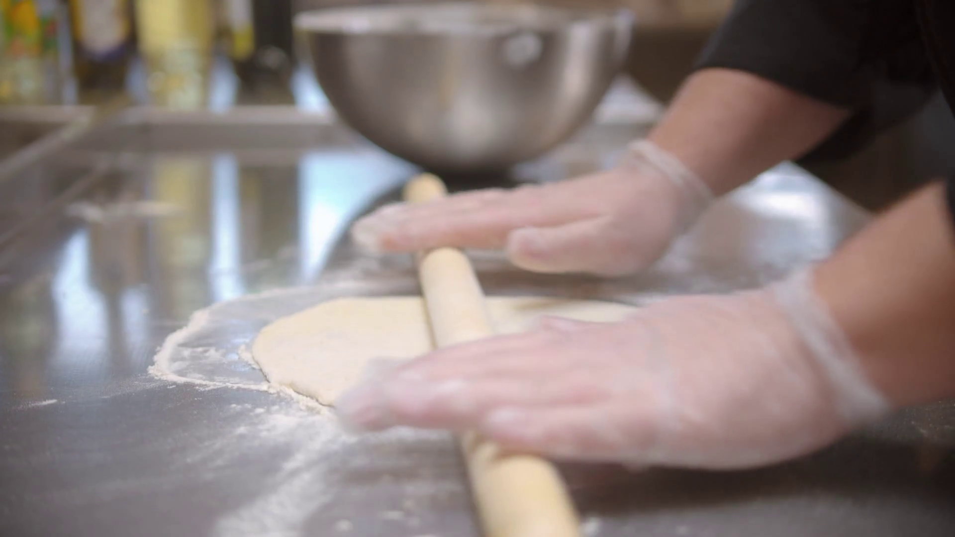 Restaurant kitchen making a dough flatten the dough with a rolling