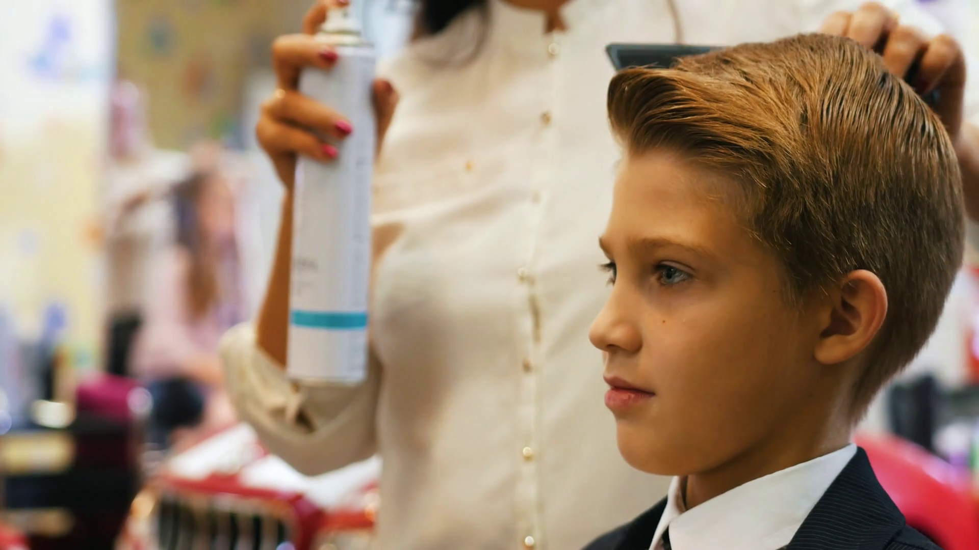 Stylist combs little boy's hair with hairspray Stock Video Footage 00