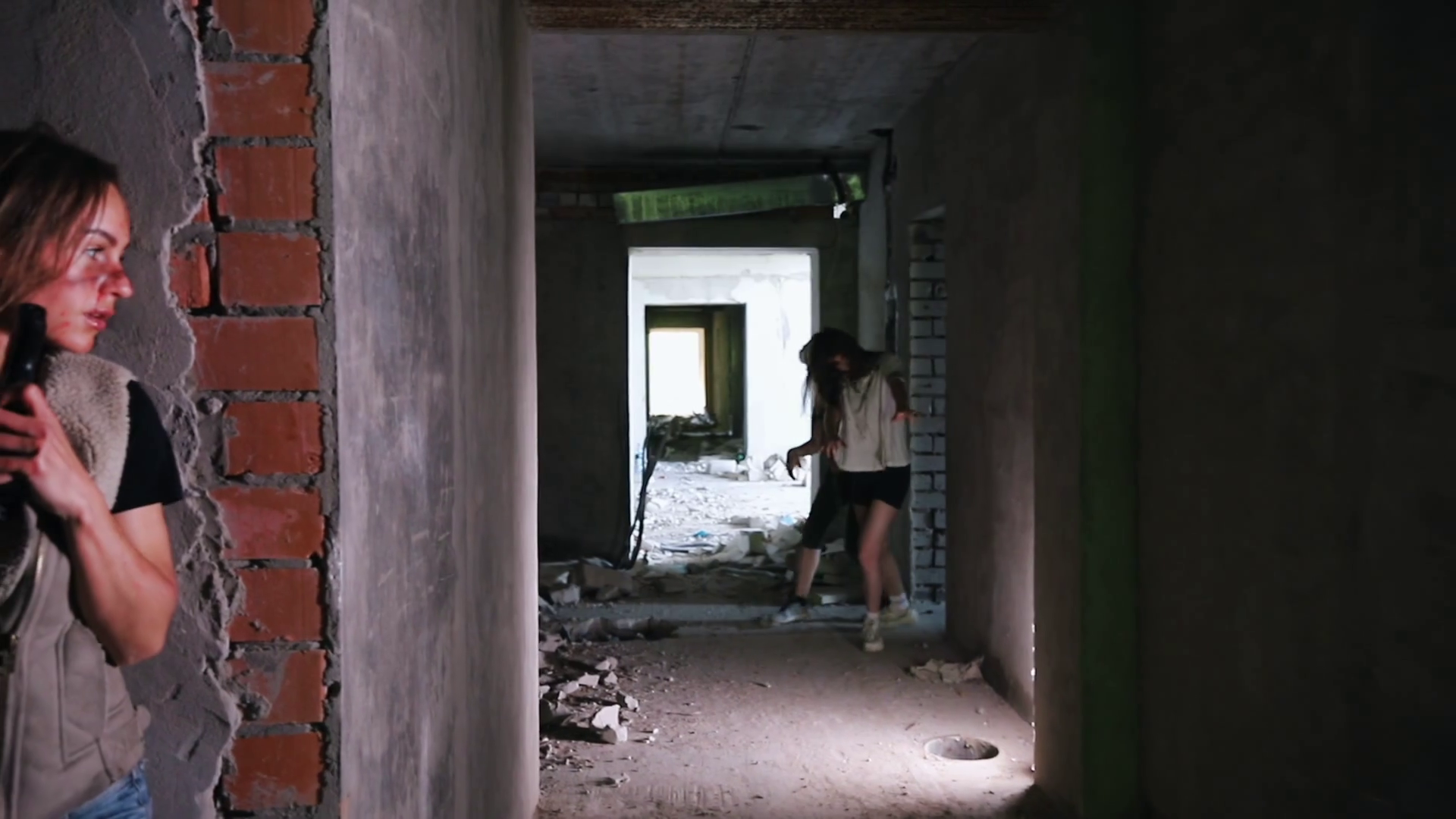 Survived woman while the zombie apocalypse with a gun hiding behind a