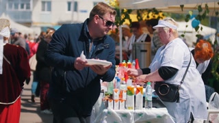 Tatarstan, Laishevo 25-05-2019: A woman stands on the hand and puts food in the plate