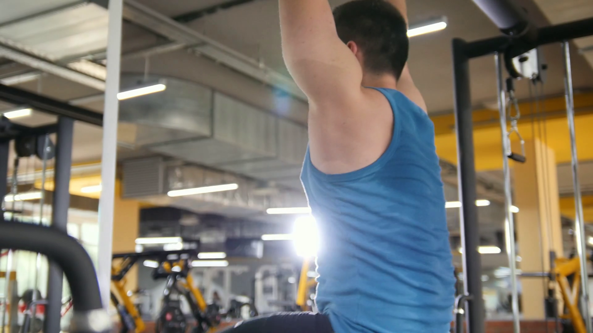 Young man athlete doing pullup bar abdominal exercise in