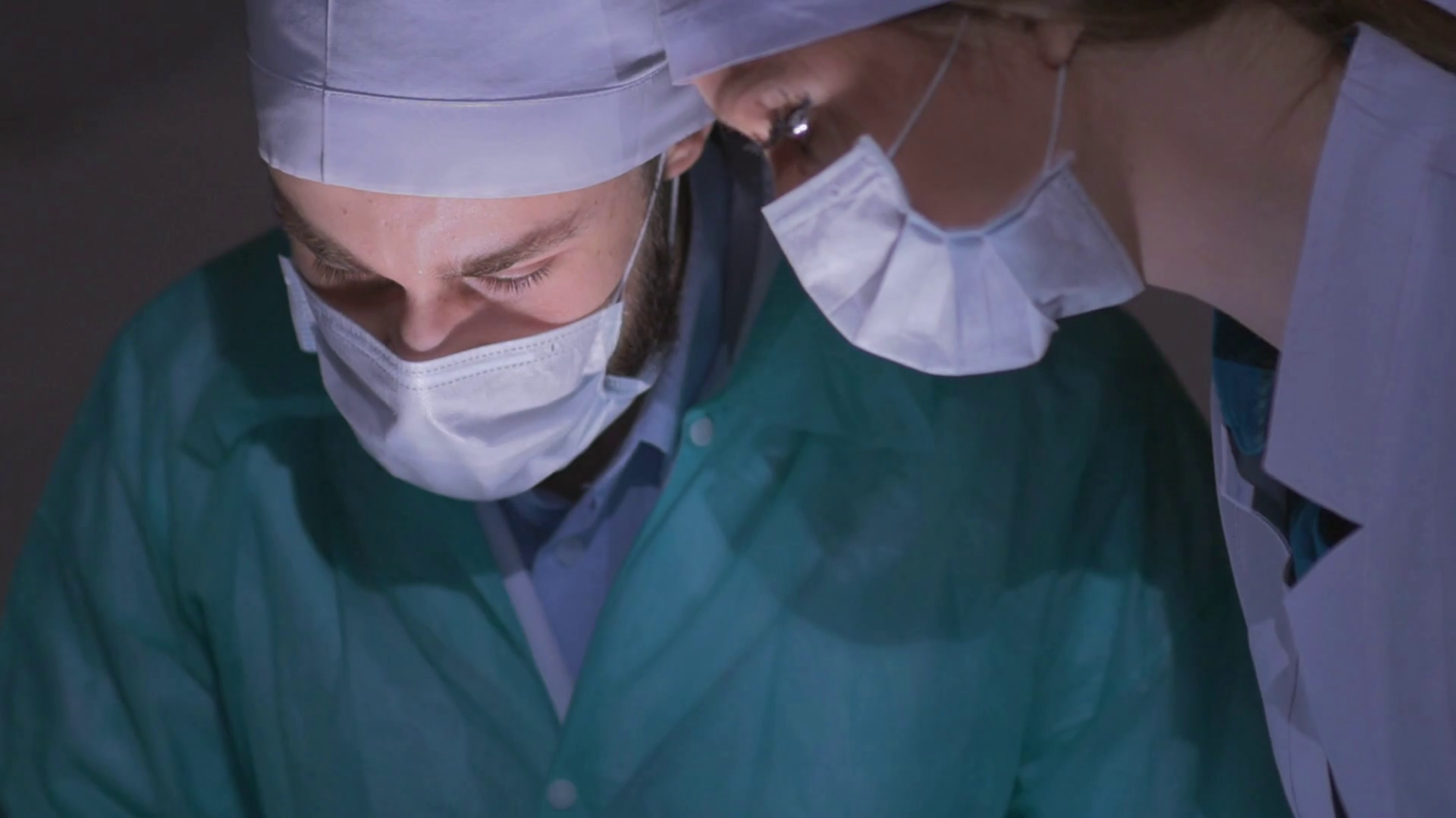 Doctors surgeons operate patient in operating theater, tilt down