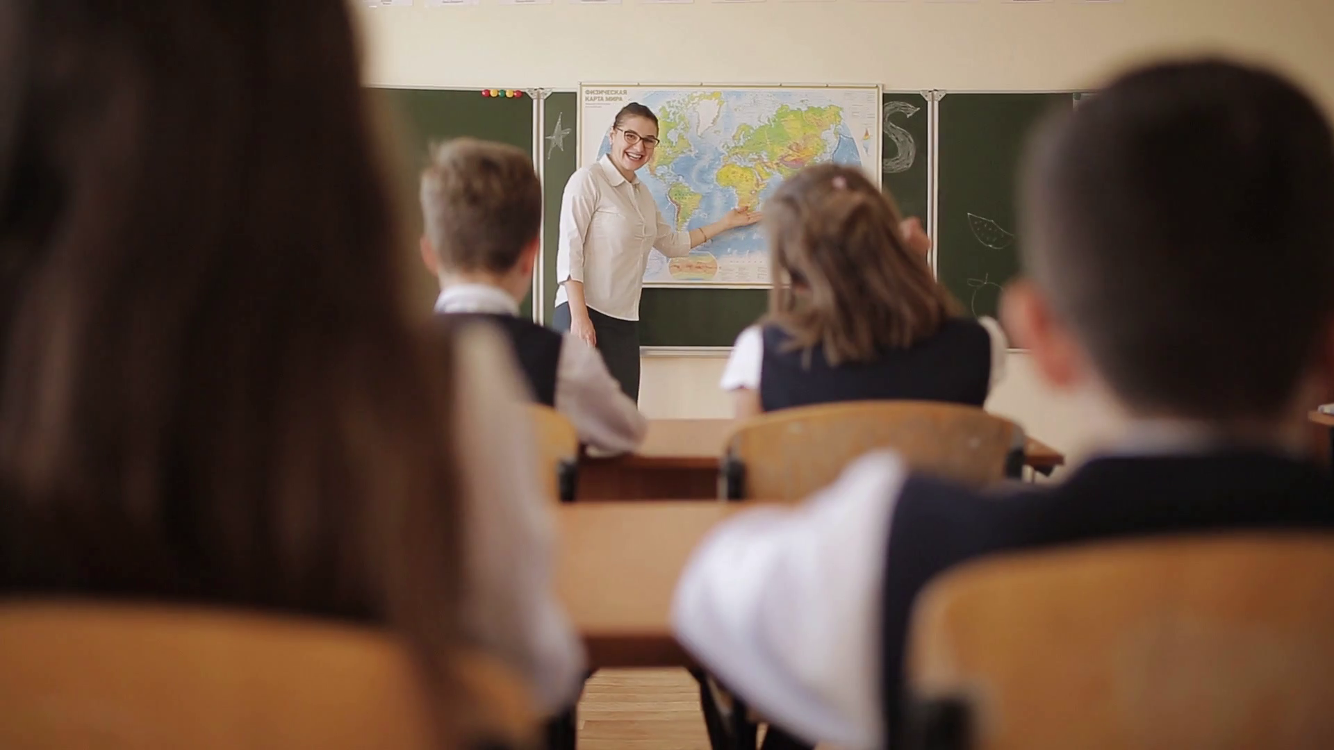 The geography teacher tells the students in the class the topic of the lesson and asks questions