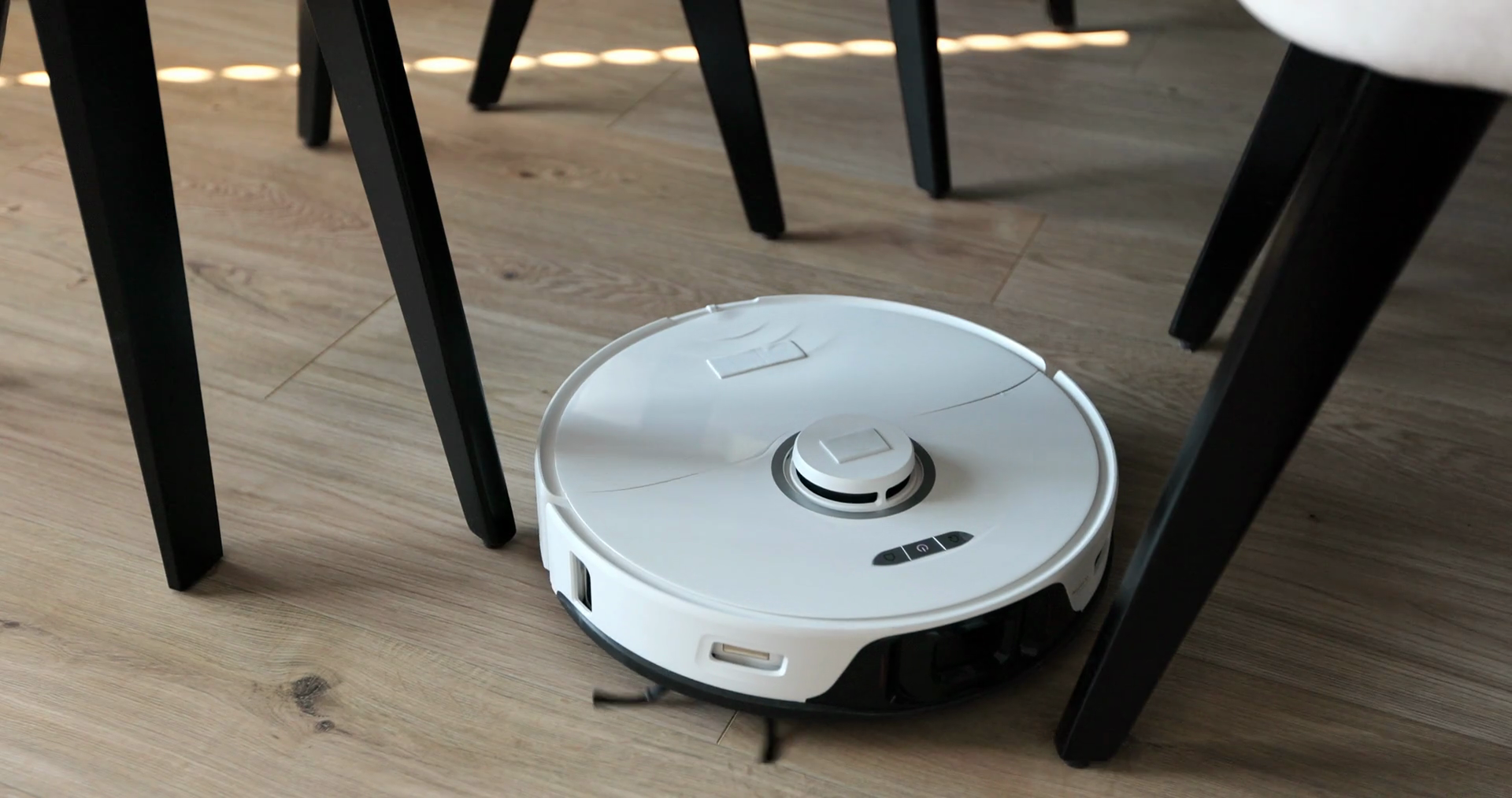 Robot Vacuum Cleaner Moving Between Chairs Stock Footage SBV348543209