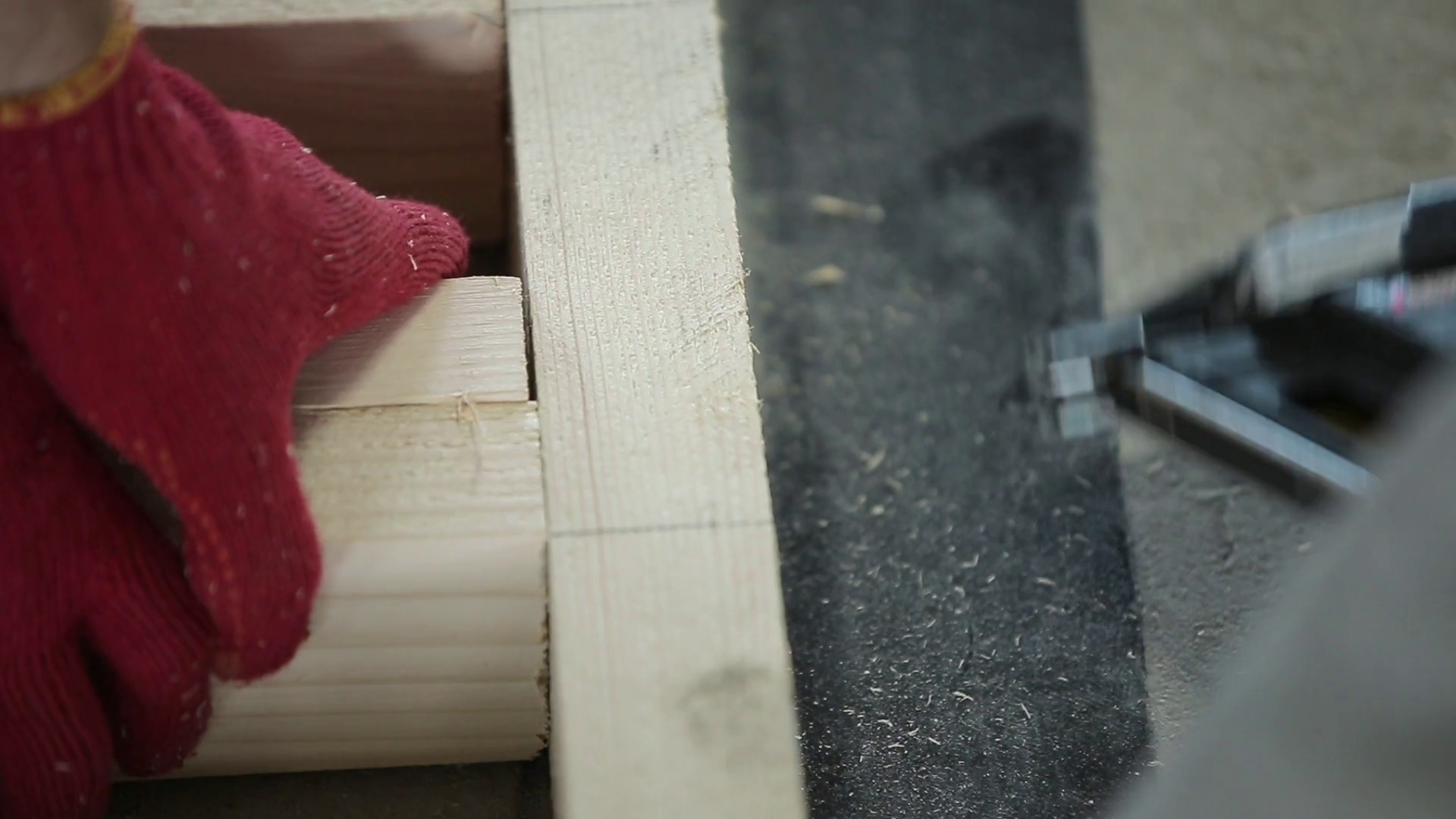 Wood production, joiner using nail gun to hammering nails in beams on