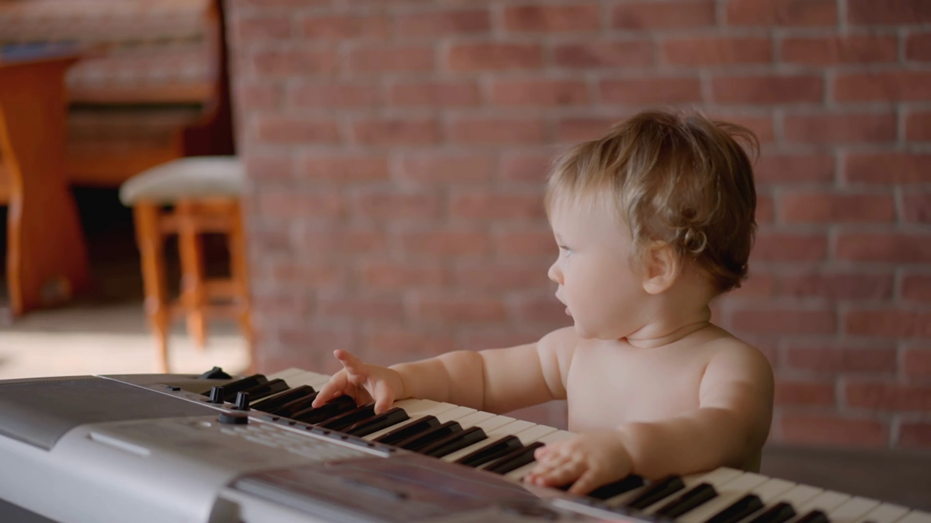 Asian baby girl toddler playing electric piano, sit down on the floor